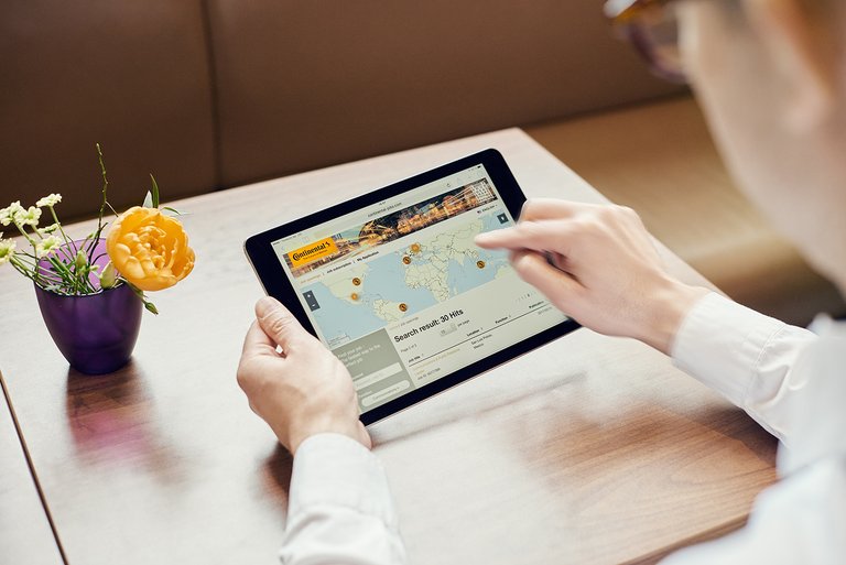 Un bărbat caută un post vacant în portalul de locuri de muncă Continental pe tableta sa