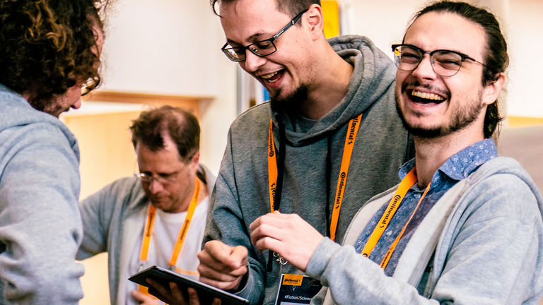 A group of smiling people with yellow Continental lanyards around their necks.