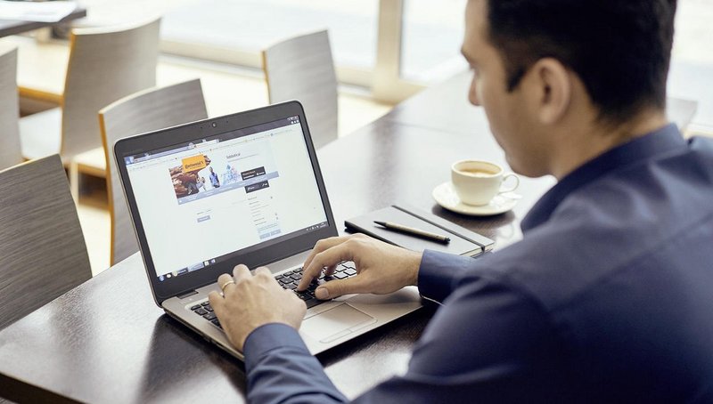 Ein Mann sitzt an seinem Schreibtisch mit seinem Laptop vor ihm und nimmt an unserem Online-Assessment teil