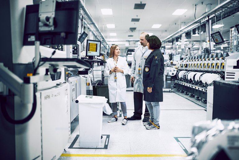 Three people exchanging in a labaroatory about new advancementss