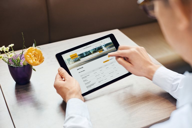 A man is looking for a vacant position in Continental's Job Portal on his tablet