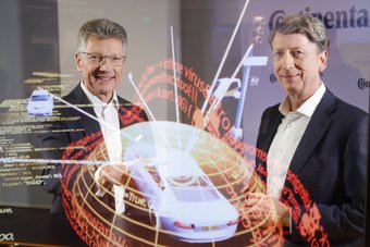 Continental CEO Dr. Elmar Degenhart and CFO Wolfgang Schäfer show the digital protection shield of a car.