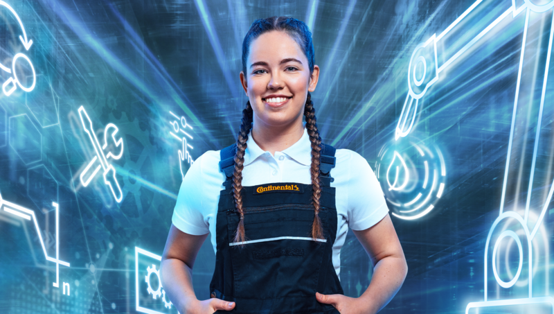 A young woman in dungarees stands with hands in her pockets in front of a dynamic background of digital symbols and smiles