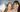 Zwei Frauen in Sakkos stehen mit verschränkten Armen beisammen und lächeln